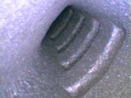 Ein Blick mit dem Endoskop in einen der Kühlkanäle der innbelüfteten Bremsscheiben an der Vorderachse. Blickrichtung: Von der Außenseite in Richtung Nabenmitte.

(Diese Bremsscheibe ist noch relativ neu, rund 500 km am Fahrzeug montiert, daher sieht das